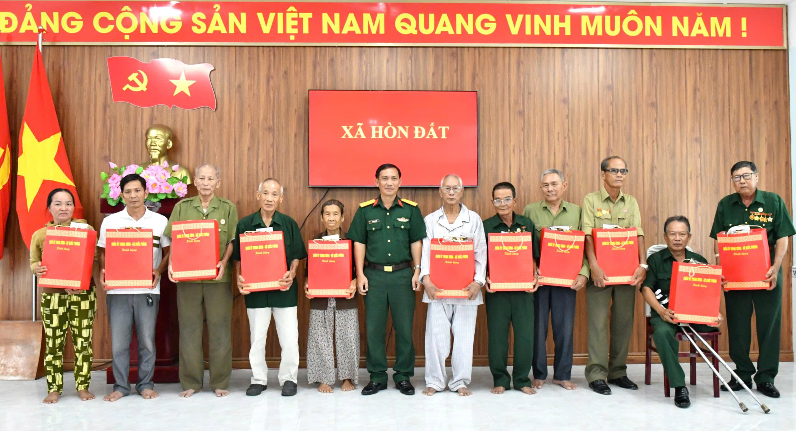 Ảnh 1: Trung tá Trương Út Bắc, Phó Chủ nhiệm Chính trị Bộ Chỉ huy Quân sự tỉnh An Giang trao tặng quà cho các gia đình chính sách người có công tại xã Hòn Đất