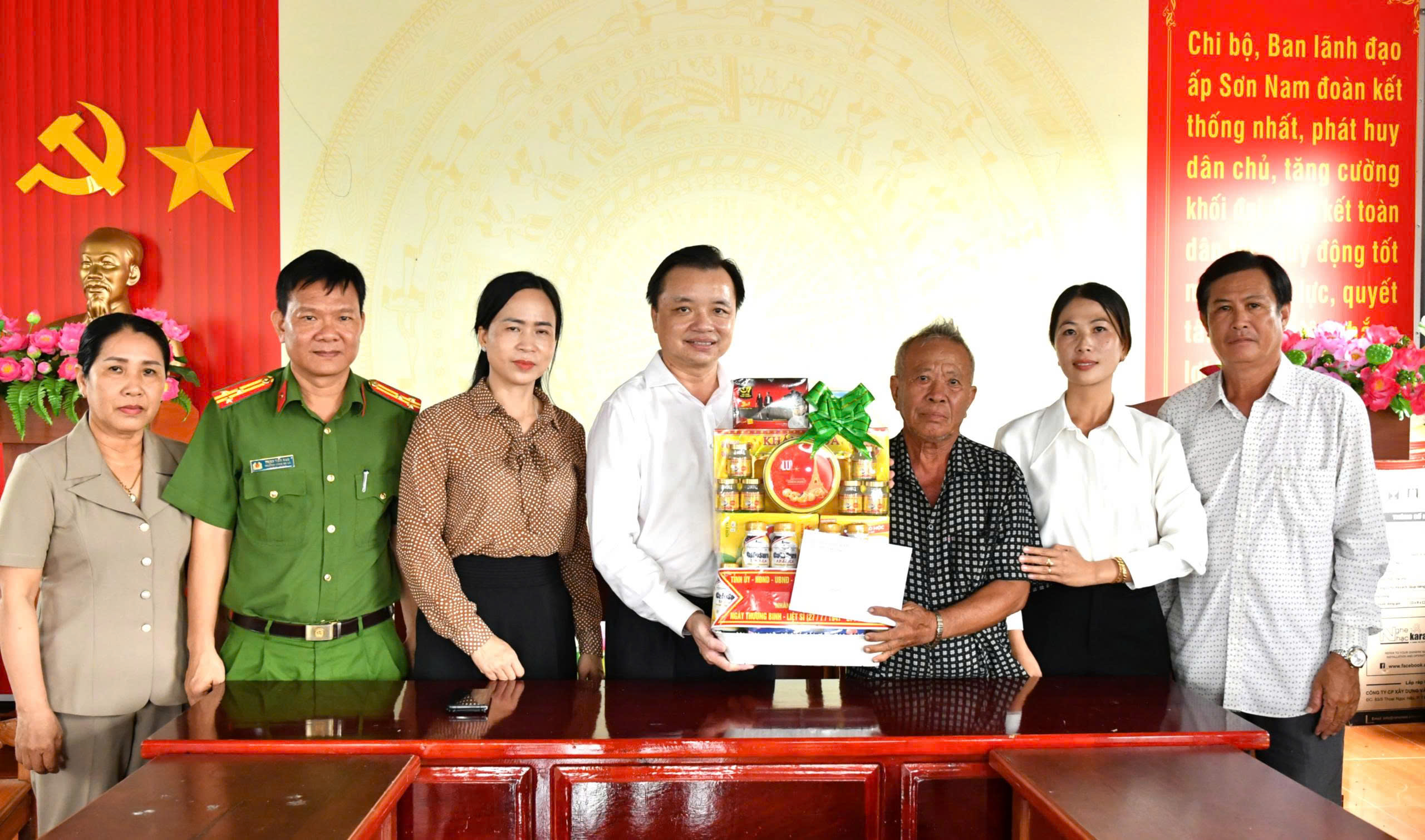 Ảnh 2: Bí thư Đảng ủy xã Hòn Đất Dương Minh Tâm (giữa) tặng quà cho gia đình ông Vũ Xuân Thanh, thương binh, ngụ ấp Sơn Nam.