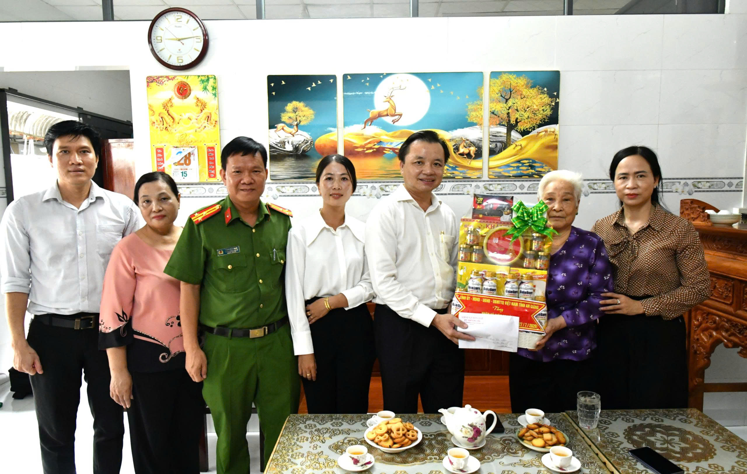 Ảnh 1: Bí thư Đảng ủy xã Hòn Đất Dương Minh Tâm (thứ ba, từ phải qua) tặng quà cho gia đình bà Đoàn Thị Hém, thương binh và thờ cúng liệt sĩ, ngụ ấp Tri Tôn.