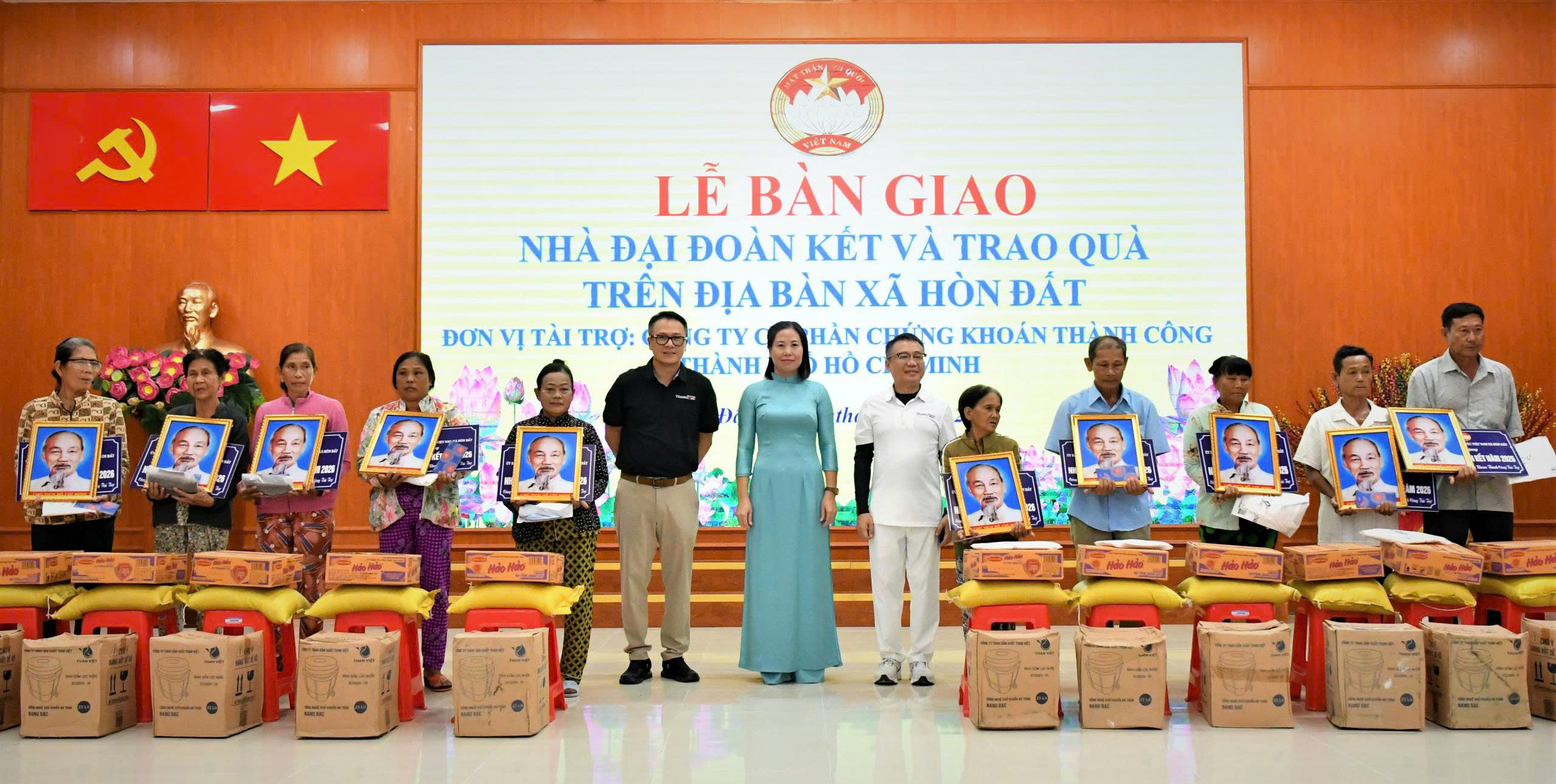 Ảnh 2: Chủ tịch UBND xã Hòn Đất Phạm Thu Thủy cùng đại diện đơn vị tài trợ trao bảng tượng trưng tặng Nhà Đại đoàn kết cho các hộ gia đình.