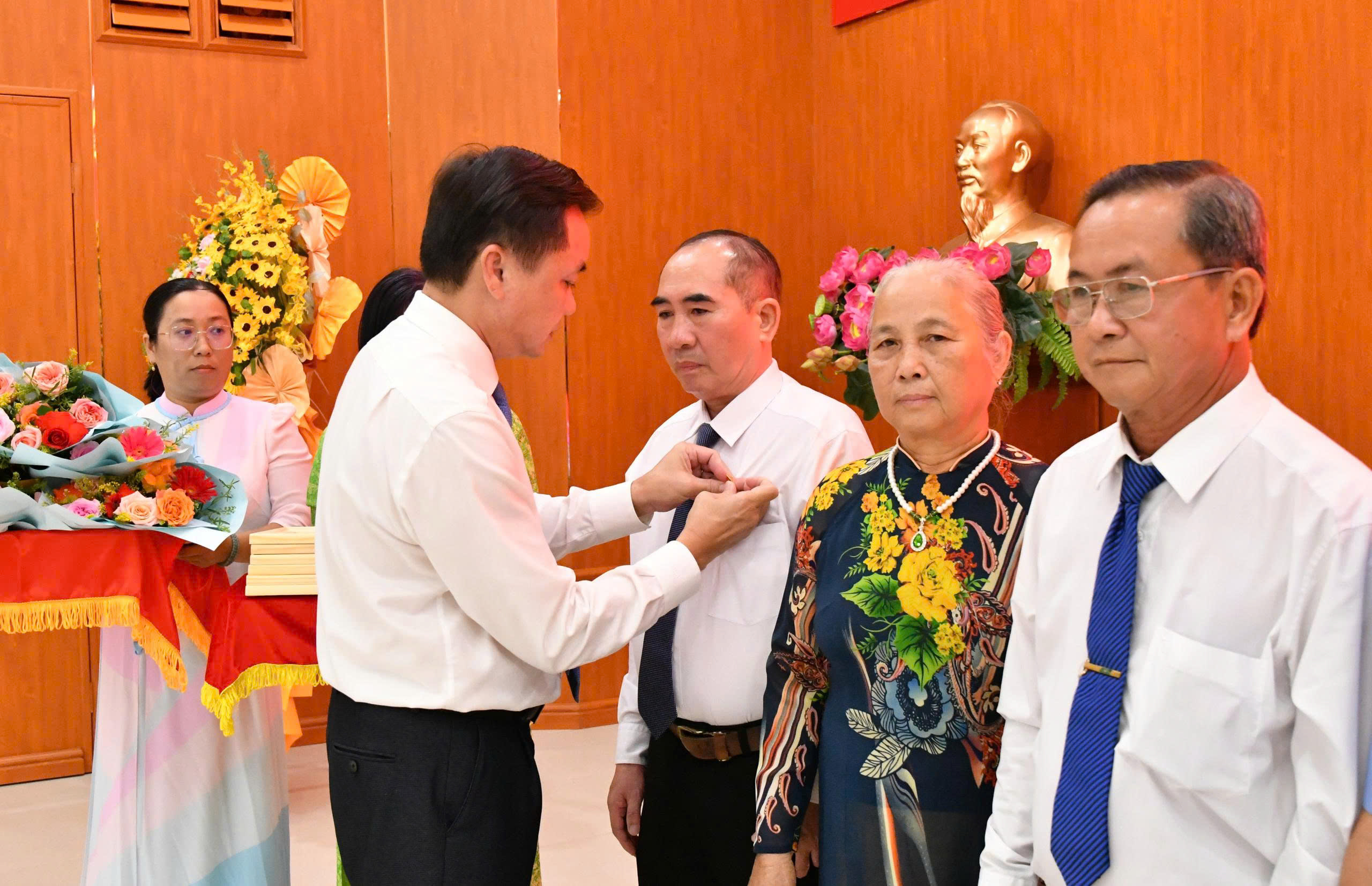 Ảnh 2, 3: Bí thư Đảng ủy xã Hòn Đất Dương Minh Tâm trao Huy hiệu 35 năm tuổi Đảng cho các đảng viên.