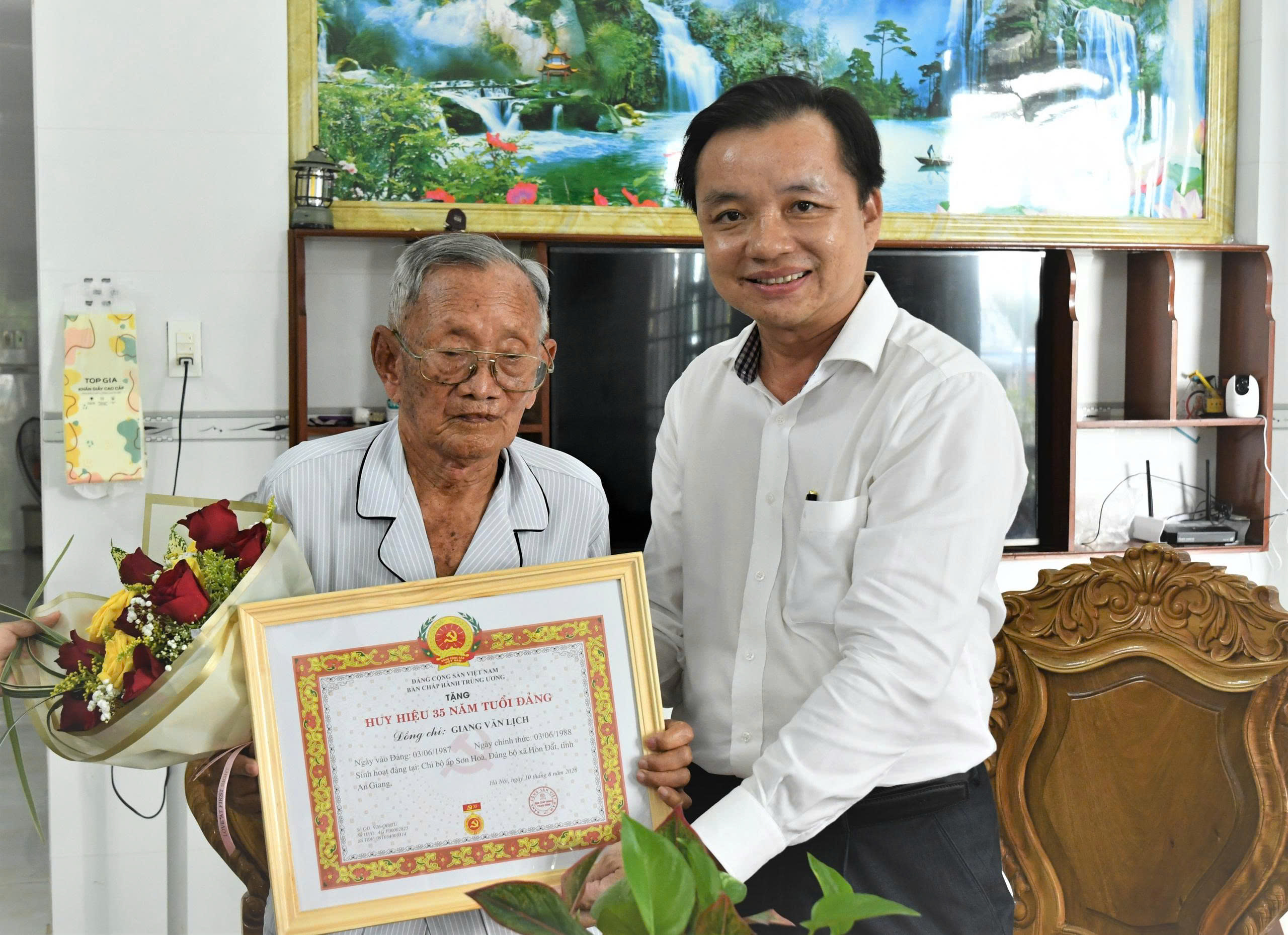 Ảnh 1: Bí thư Đảng ủy xã Hòn Đất Dương Minh Tâm trao huy hiệu đảng và tặng hoa chúc mừng đảng viên Giang Văn Lịch