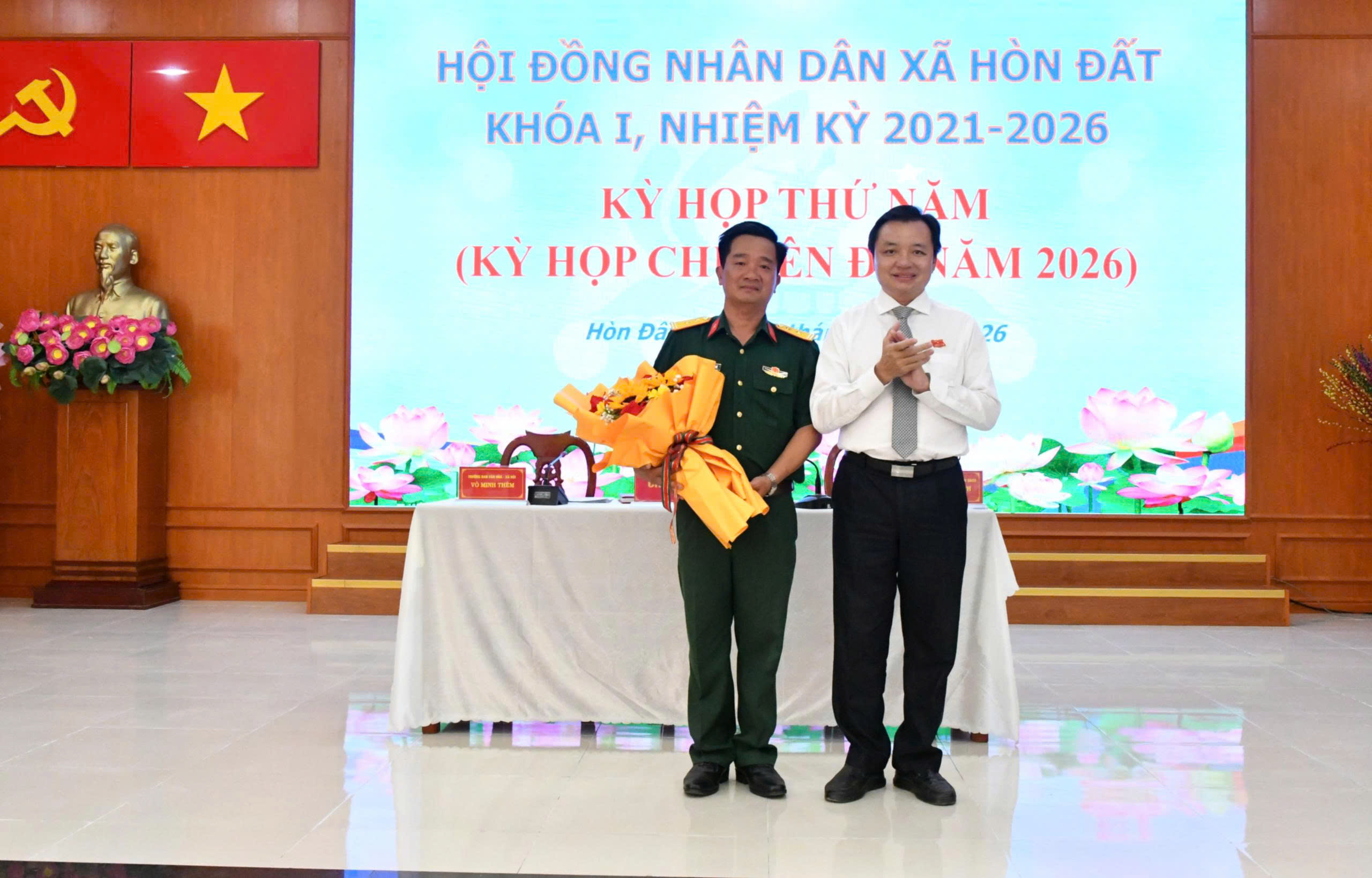 Ảnh 1: Đồng chí Dương Minh Tâm – Bí thư Đảng uỷ xã Hòn Đất trao tặng hoa chúc mừng Trung Tá Nguyễn Hoàng Nhớ - Chỉ huy trưởng Ban chỉ huy quân sự xã Hòn Đất