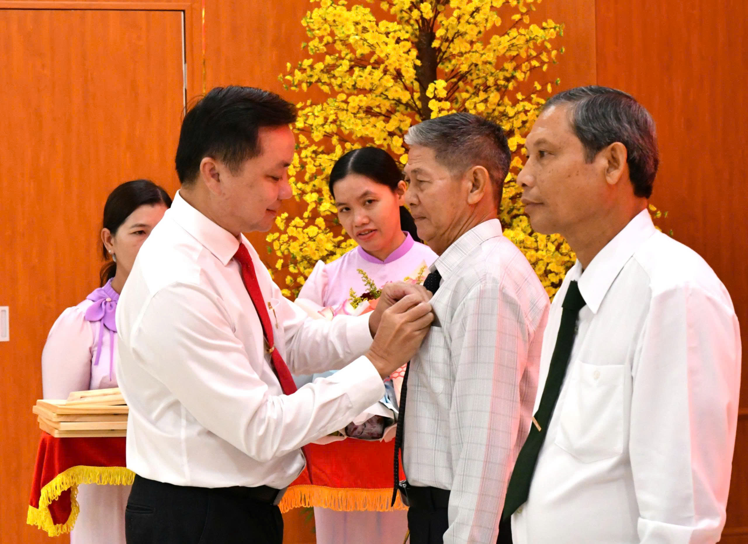 Ảnh 2: Bí thư Đảng uỷ xã Hòn Đất Dương Minh Tâm trao huy hiệu 40 năm tuổi đảng cho đảng viên Hà Văn Liên, chị bộ ấp Hoà Thuận