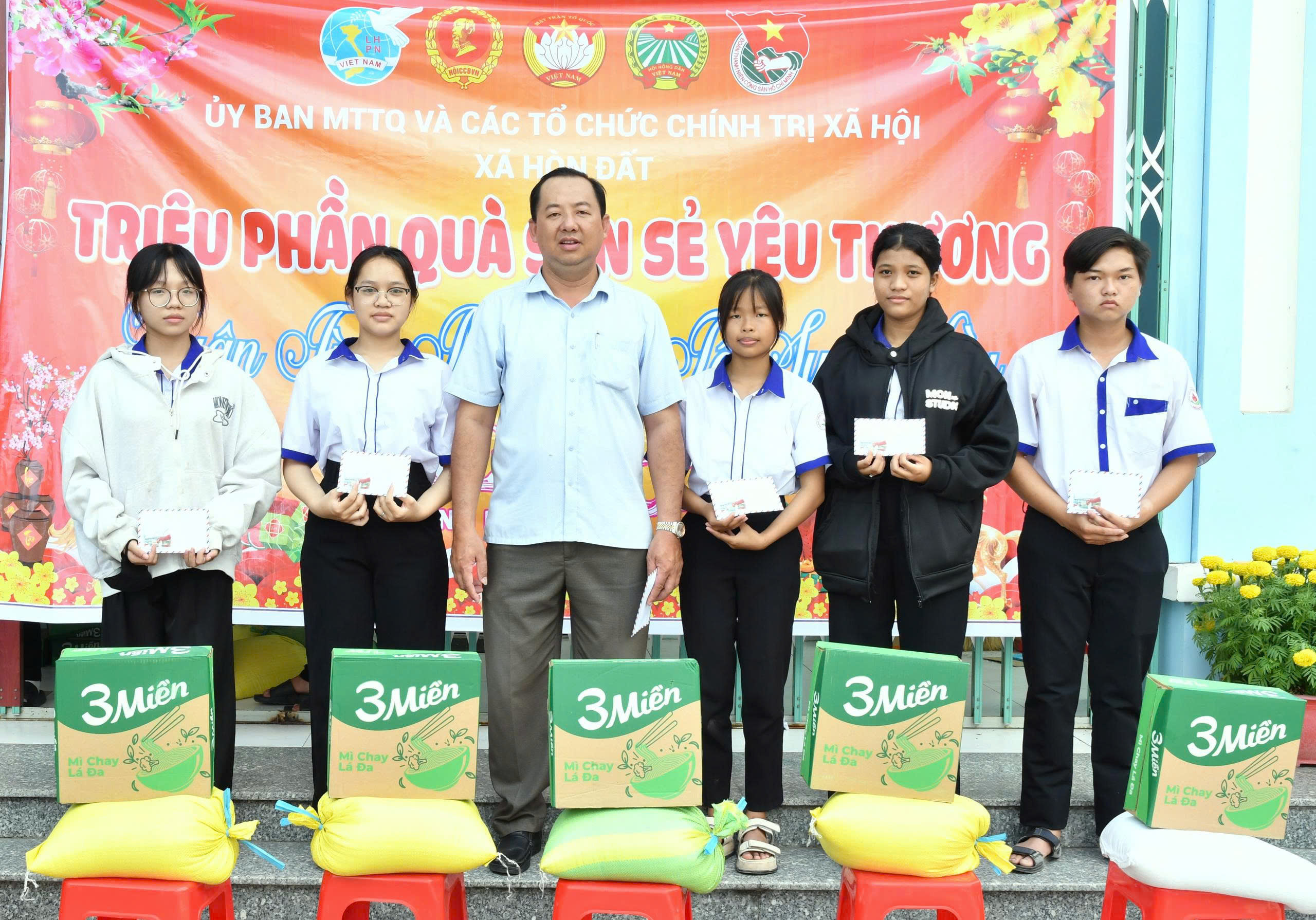 Ảnh 2: Đồng chí Vũ Văn Nghĩa – Chủ tịch Uỷ ban MTTQ Việt Nam xã Hòn Đất trao tặng quà cho học sinh nghèo