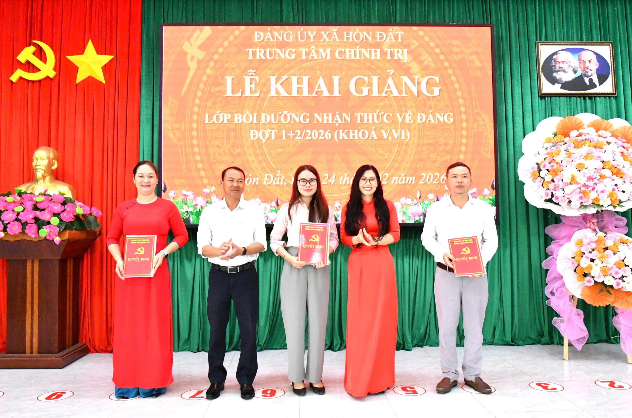 Ảnh 1:  Đồng chí Trần Thị Ngọc Trầm (áo dài đỏ) – Giám đốc Trung tâm chính trị xã Hòn Đất trao quyết định phân công chủ nhiệm lớp và Ban cán sự Bồi dưỡng nhận thức về Đảng (đợt 1)