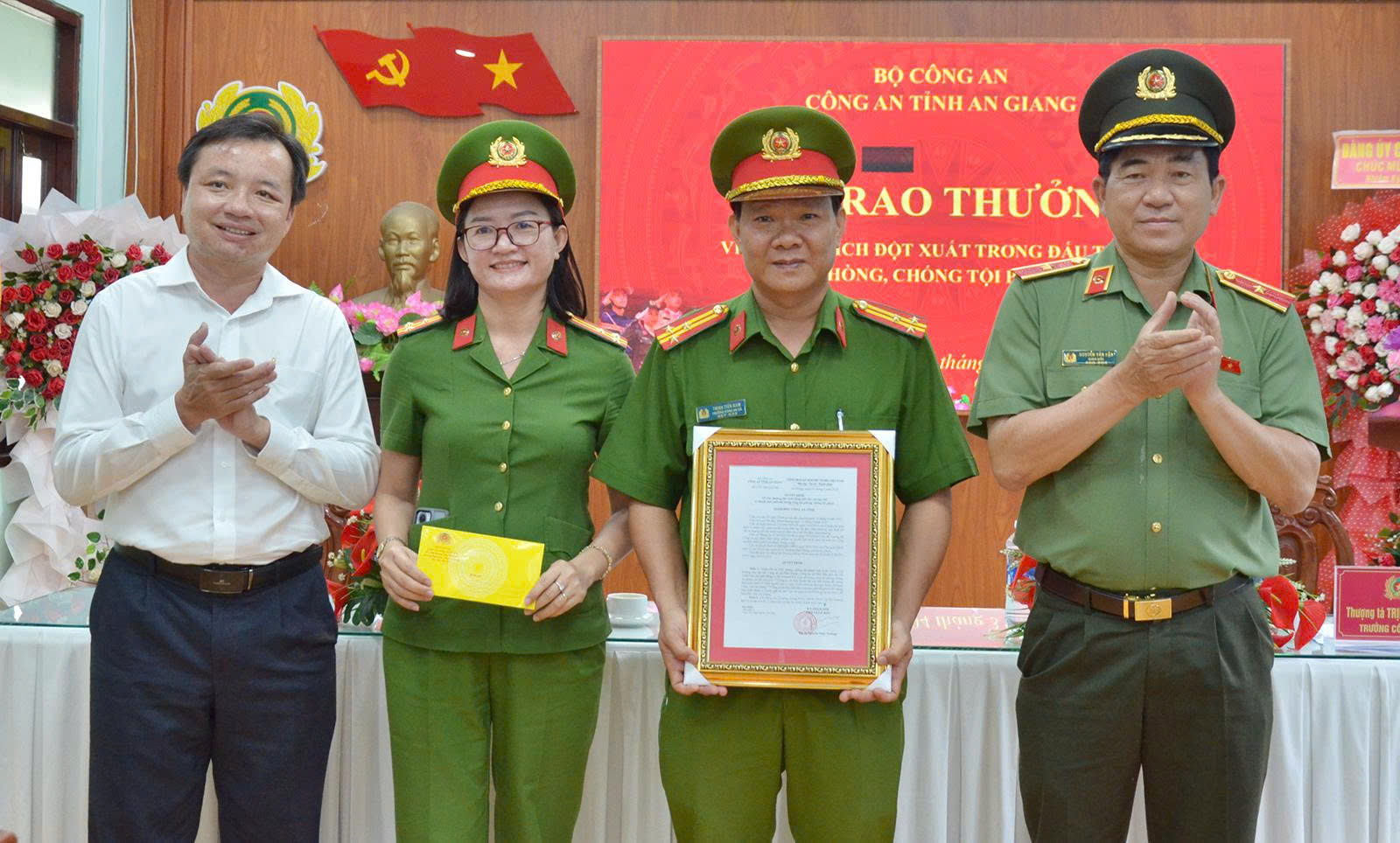 Chú thích ảnh: Thiếu tướng Nguyễn Văn Hận (bìa phải), Giám đốc Công an tỉnh An Giang; Bí thư Đảng ủy xã Hòn Đất Dương Minh Tâm (bìa trái) trao quyết định thưởng cho Công an xã Hòn Đất.