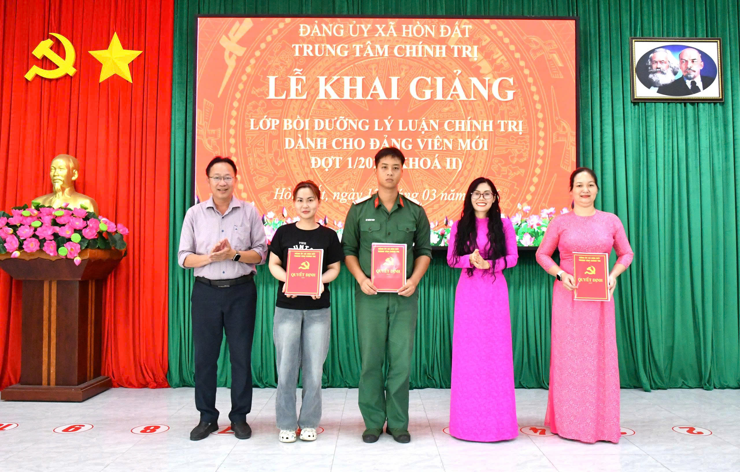 Ảnh 1: Đồng chí Trần Thị Ngọc Trầm (áo dài hồng) - Giám Đốc Trung tâm chính trị xã Hòn Đất đã trao quyết định phân công Chủ nhiệm lớp và Ban cán sự lớp bồi dưỡng lý luận chính trị dành cho đảng viên mới đợt 1/2026, khoá 2.