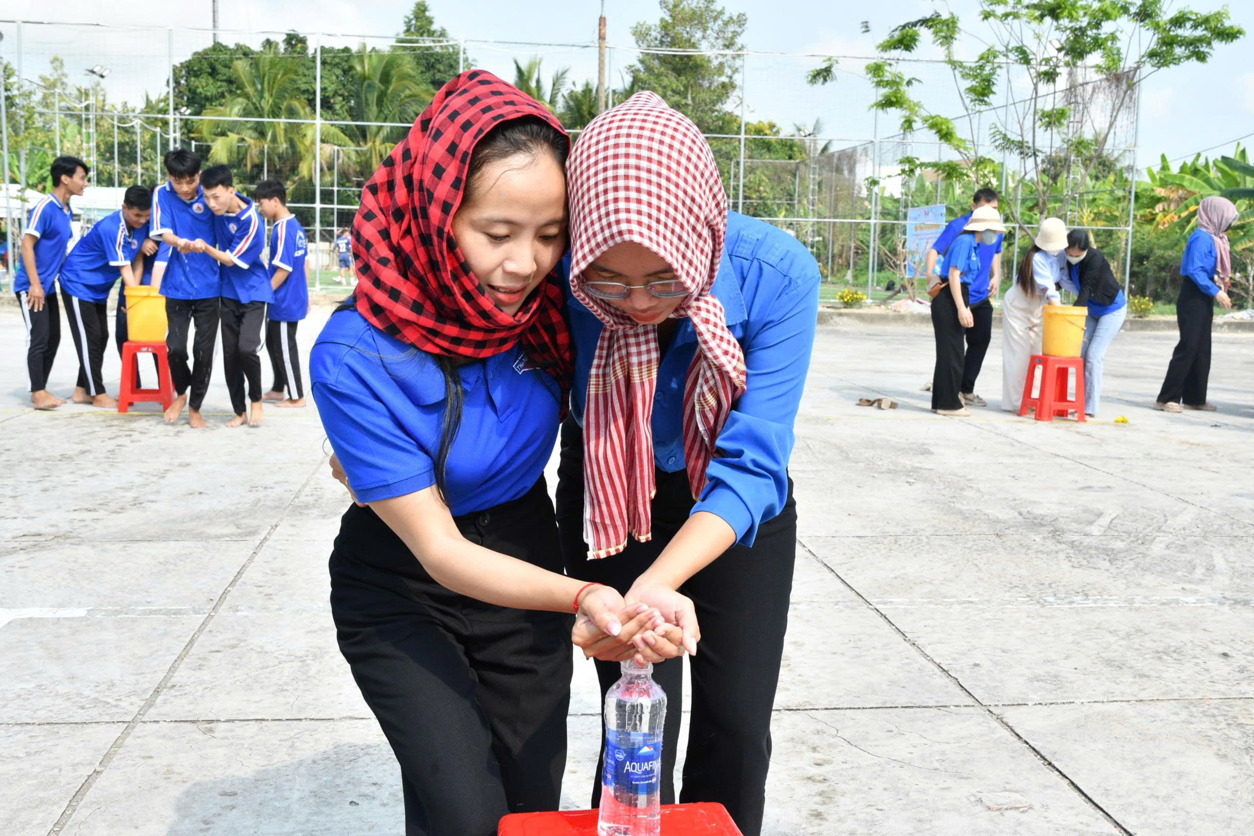 Ảnh 4: tham gia dùng tay rót nước vào chai rỗng