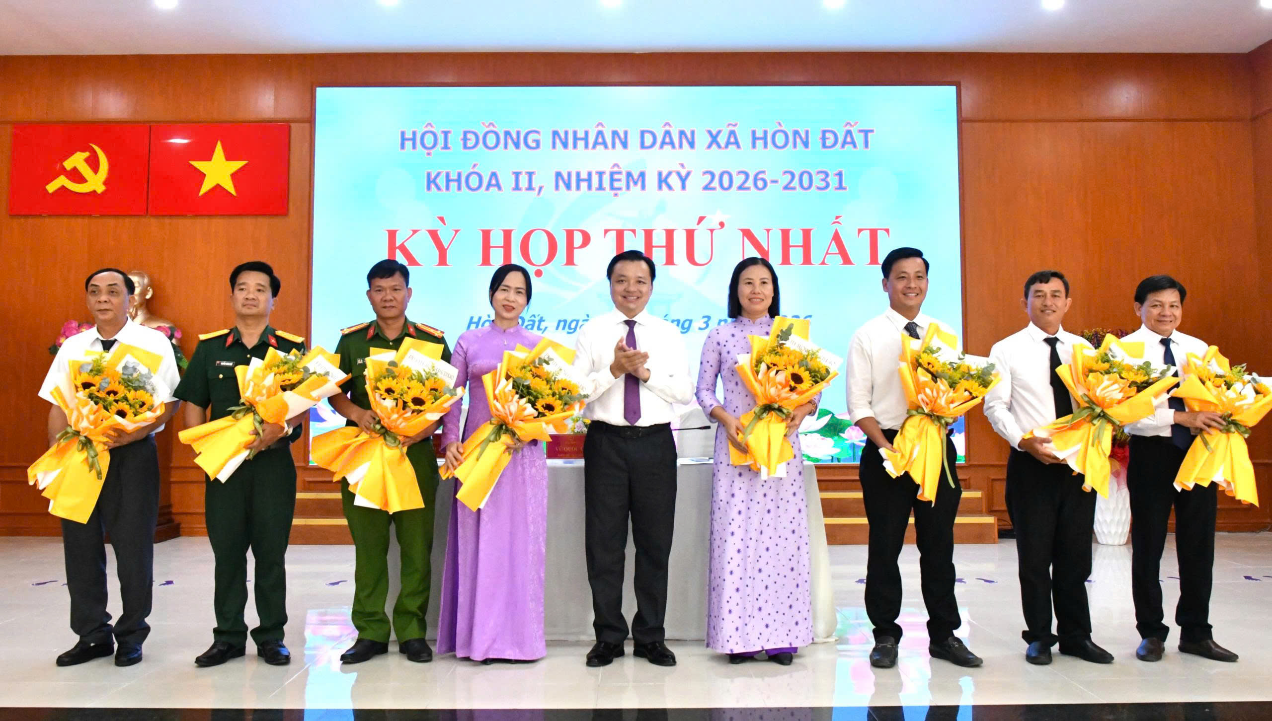 Ảnh 2: Bí thư Đảng ủy xã Hòn Đất Dương Minh Tâm tặng hoa chúc mừng Chủ tịch, Phó Chủ tịch UBND xã và thành viên UBND xã Hòn Đất, nhiệm kỳ 2026-2031.