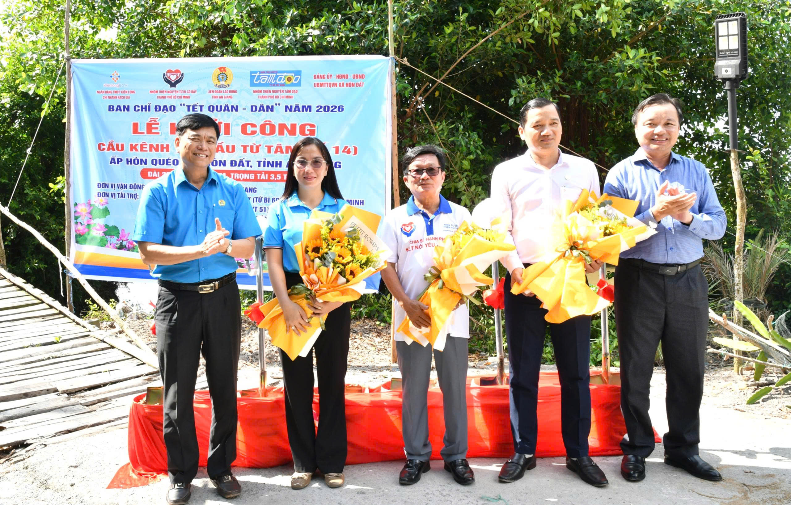 Ảnh 2: đồng chí Đỗ Trần Thịnh - Tỉnh uỷ viên, Phó Chủ tịch UBMTTQ Việt Nam tỉnh, Chủ tịch Liên đoàn Lao động tỉnh An Giang và đồng chí Dương Minh Tâm – Bí thư Đảng uỷ xã Hòn Đất tặng hoa cho các đơn vị tài trợ.