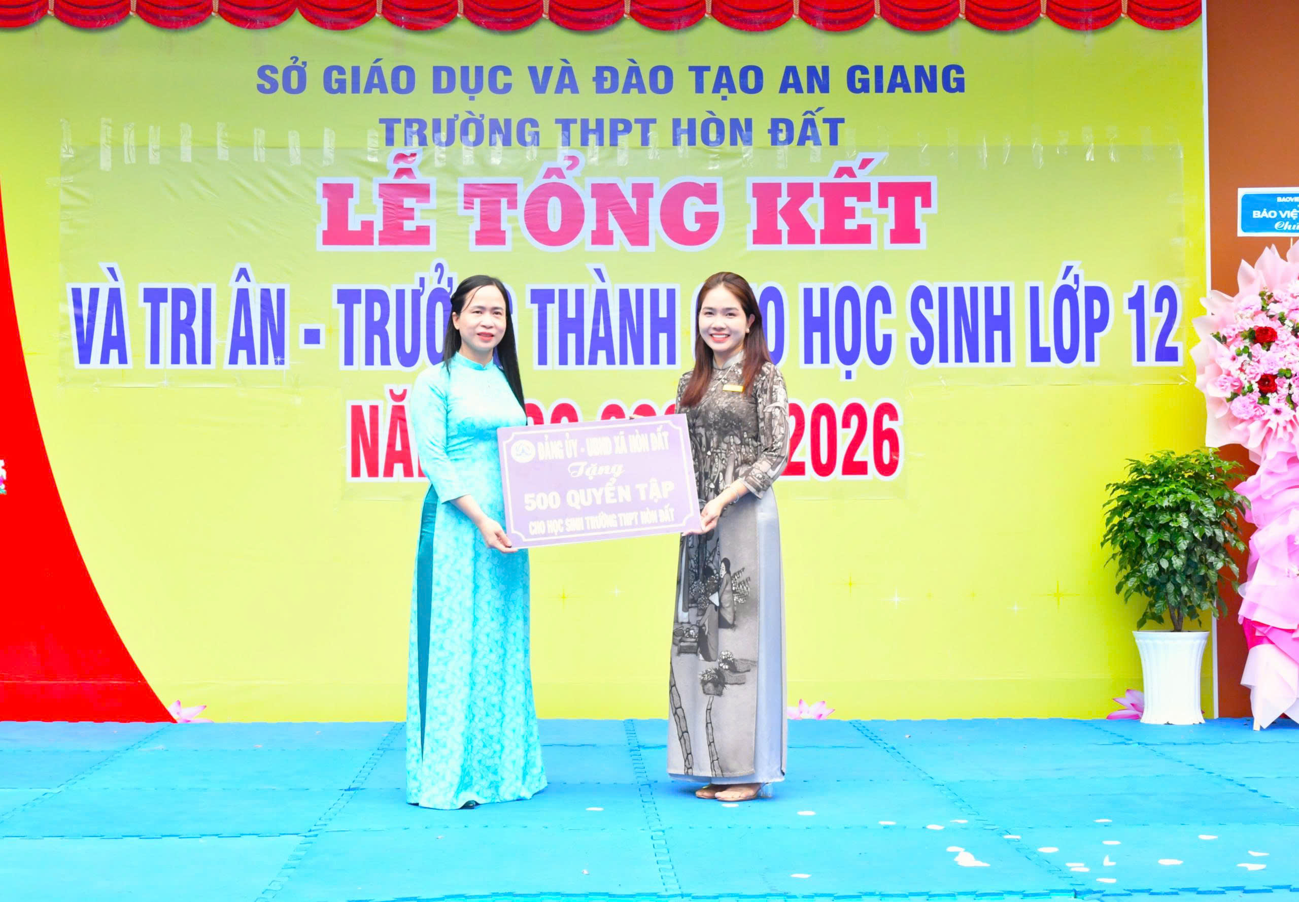 Ảnh 1: Đồng chí Đào Thị Thu Huyền – Phó Chủ tịch UBND xã Hòn Đất trao bảng tương trưng tặng 500 quyển tập cho Trường THPT Hòn Đất