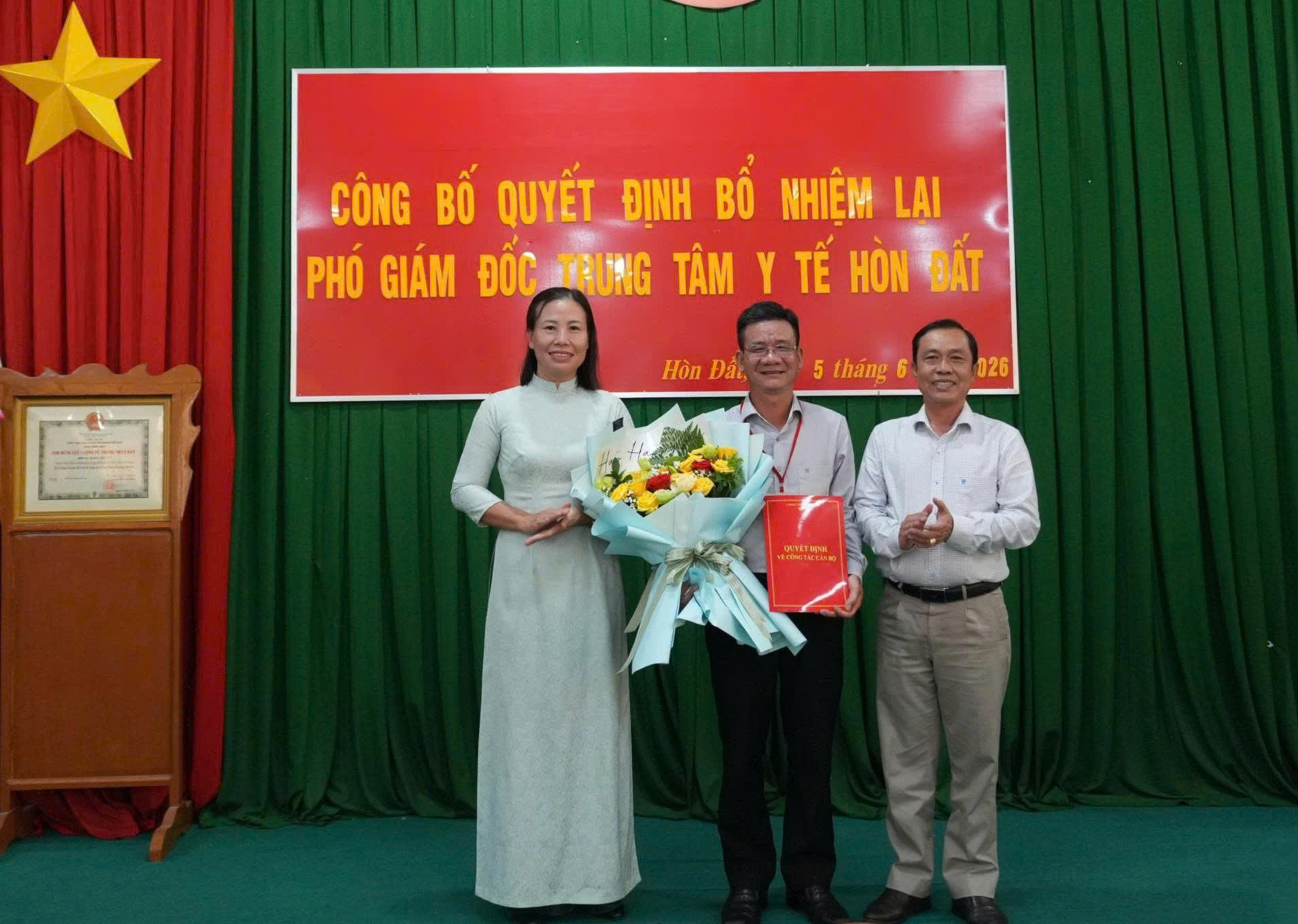 Ảnh: đồng chí Đoàn Thanh Hùng – Phó Giám đốc Sở y tế An Giang và đồng chí Phạm Thu Thủy- Phó Bí thư Đảng uỷ, Chủ tịch UBND xã Hòn Đất đã trao quyết định và trao tặng hoa chúc mừng đồng chí Trần Hải Toàn