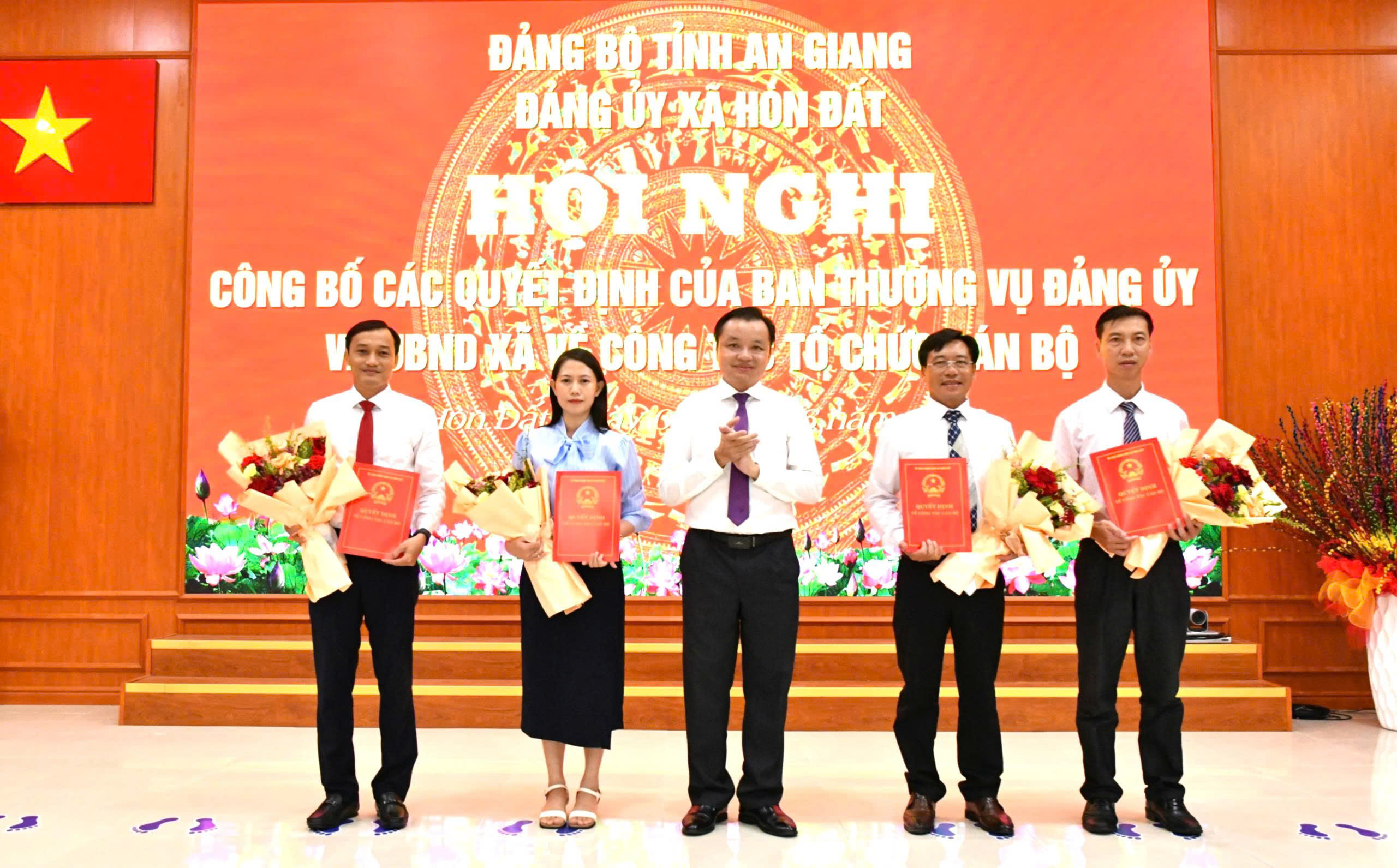 Ảnh 1: Đồng chí Dương Minh Tâm – Bí thư Đảng uỷ xã Hòn Đất trao quyết định và tặng hoa cho các đồng chí được điều động, bổ nhiệm 