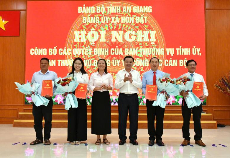 Bí thư Đảng uỷ xã Hòn Đất Dương Minh Tâm và đồng chí Phạm Thu Thủy - Phó Bí thư Đảng uỷ, Chủ tịch UBND xã Hòn Đất trao quyết định và tặng hoa chúc mừng