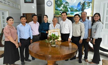 Bí thư Đảng ủy xã Hòn Đất Dương Minh Tâm trao huy hiệu đảng và tặng hoa chúc mừng đảng viên Giang Văn Lịch